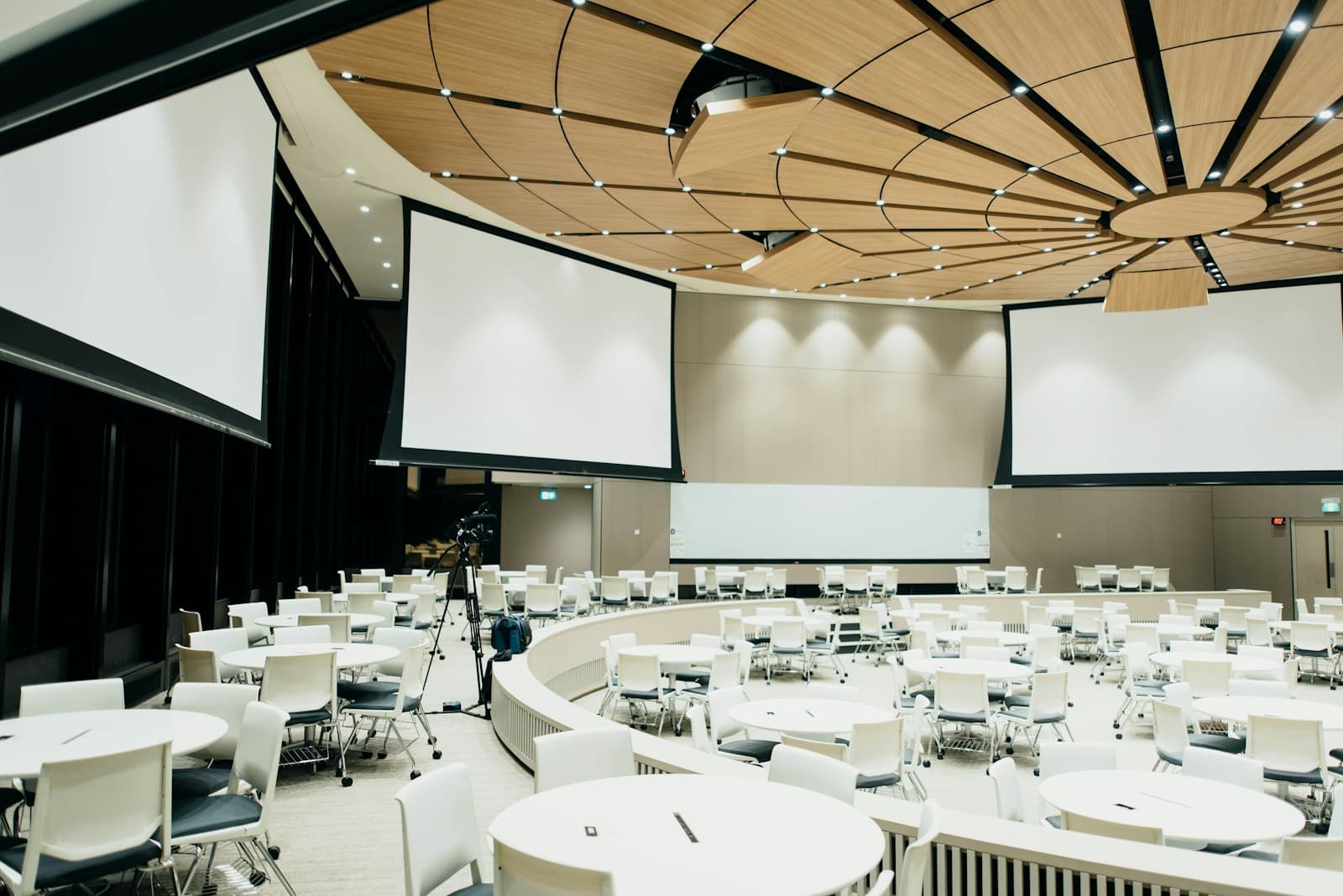 Wide view of conference seating and projection screens